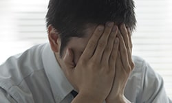 Person with hands covering his face